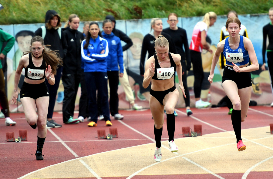 Bei widrigen &auml;u&szlig;eren Bedingungen war U16-Sprinterin Maja Bolinger (Mitte) vom LAZ Soest - hier mit Clara Dietrich (rechts, TV Werne) und Lina Marleen Thimm (links, TSV Hagen) &uuml;ber 100 Meter in 12,62 Sekunden die schnellste Athletin beim Abendsportfest in Hemer. Foto: Bottin