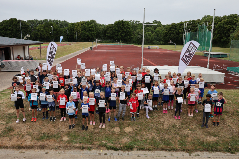 Freudestrahlende Teilnehmende nach einem erfolgreichen Wettkampftag|Romy aus dem U8-Team des LAZ Soest in Aktion bei der Hindernisstaffel. Foto: Bottin|U8-Kinder des USC Bochum beim Wechselvorgang in der Hindernisstaffel. Foto: Bottin|So gehts: Eine Dortmunder Trainerin zeigt ihren Sch&uuml;tzlingen die richtige Haltung beim Absprung. Foto: Bottin|Au&szlig;ergew&ouml;hnlich: Eine perfekte Wurfauslage beim Schlagballwurf demonstriert hier Sophie Bornemann aus dem U12-Team des LAZ Soest. Foto: Bottin|Trainerin Maleen Klee mit drei U10-M&auml;dchen des LAZ Soest beim Aufw&auml;rmen vor der Biathlonstaffel. Foto: Bottin|In der Strafrunde bei der Biathlonstaffel. Foto: Bottin|Beim Zielwerfen in den umgedrehten Sprungkasten hie&szlig; es: Treffen oder in die Strafrunde. Foto: Bottin|Beim Zielwerfen in den umgedrehten Sprungkasten hie&szlig; es: Treffen oder in die Strafrunde. Foto: Bottin|Zahlreiche Eltern waren zur Unterst&uuml;tzung ihrer Kinder im Soester Schulzentrum vor Ort. Foto: Bottin|Kurvenlage: Lucia Heitmann vom LAZ Soest in der Strafrunde bei der Biathlonstaffel. Foto: Bottin|Trainerin Maya Klute mit Kindern des U8-Teams des LAZ Soest vor der Biathlonstaffel. Foto: Bottin|Warten auf die Siegerehrung. Foto: Bottin|Das Team der Bielefelder Turngemeinde siegte bei den U10-Kindern. Foto: Bottin|Das Team der Bielefelder Turngemeinde siegte bei den U10-Kindern. Foto: Bottin|Platz zwei: Das U12-Team des LAZ Soest mit den Trainern Jana Klee und Levi Klute. Foto: Bottin|Platz vier f&uuml;r die J&uuml;ngsten: Die U8-Kinder von LAZ-Trainerin Christiane Noll. Foto: Bottin|||